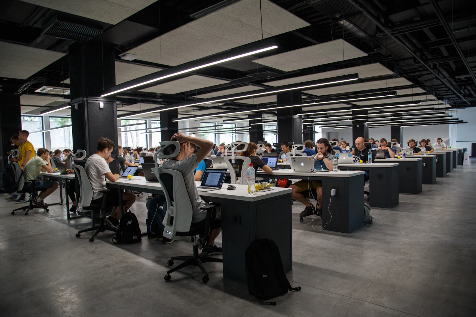 Ambiente de trabalho escuro com telas exibindo código